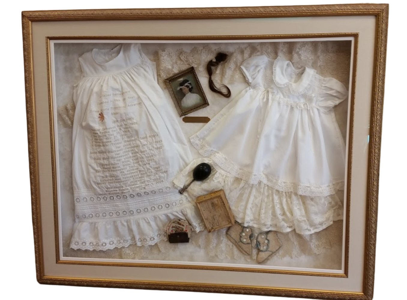 Framed antique baby dresses and accessories